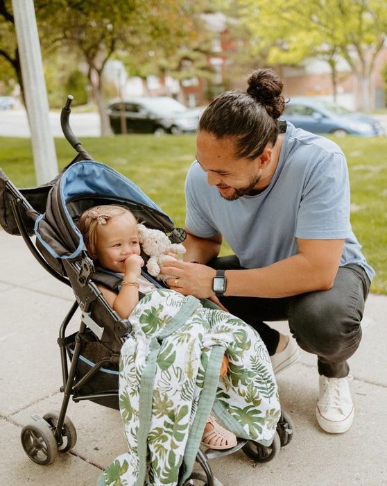 A baby snug in a stroller, wrapped up in the cozy blanket