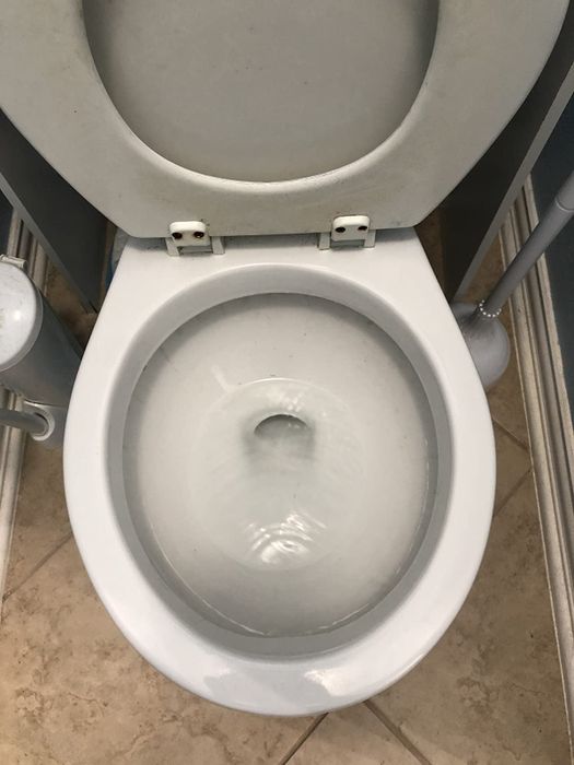 An image showing the same toilet after cleaning, now completely spotless.