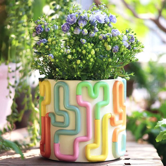 A ceramic vase with a multi-colored squiggle pattern in 3D wrapping around it