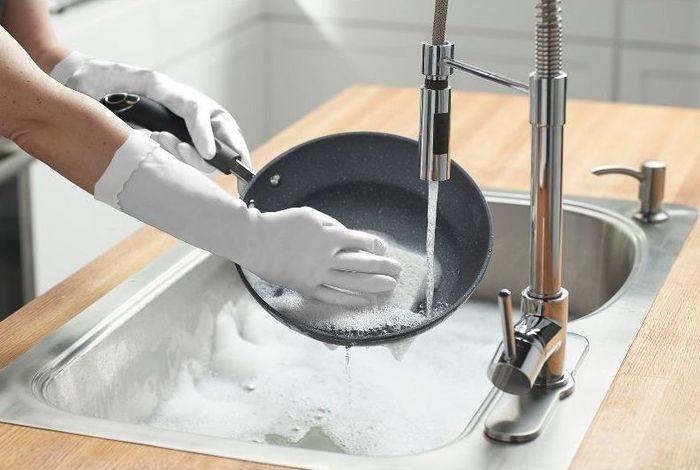 a person wears the gloves while doing dishes