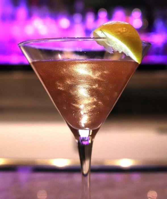 A martini glass filled with sparkling rose gold liquid