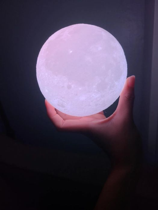 A reviewer holding the light in the dark, showcasing its glow