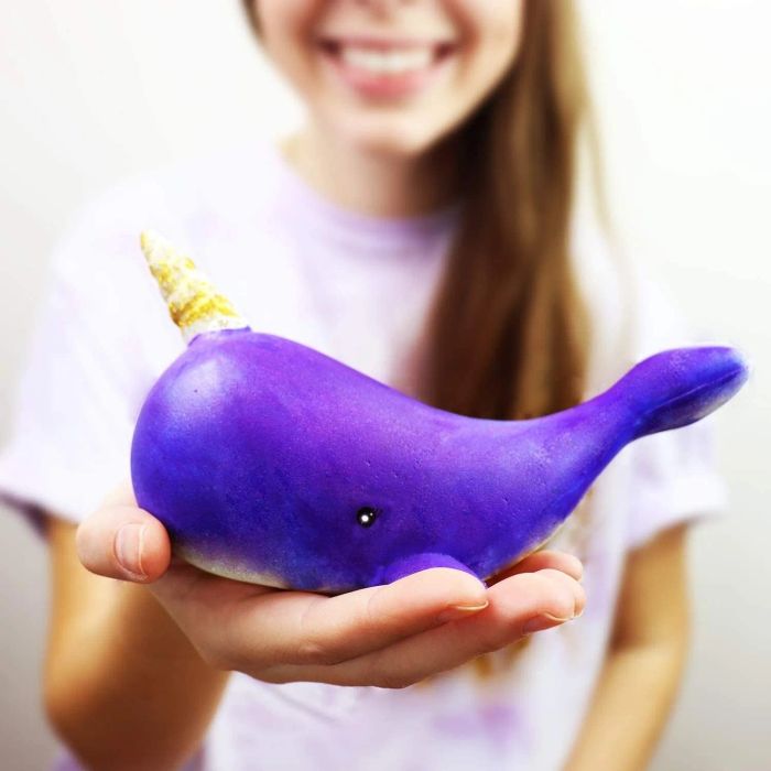 A model holding a purple narwhal squishy.