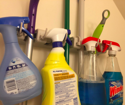 A close-up shot of the hooks designed to hold bottles of cleaning spray and long-handled cleaning tools, neatly organized for easy access.