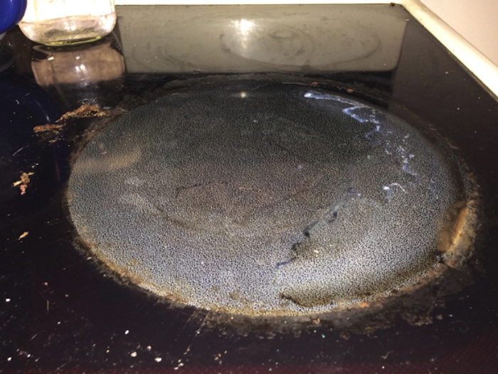 A dirty cooktop before applying the cleaning kit.