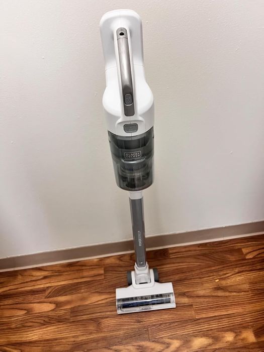 A cordless stick vacuum standing upright.
