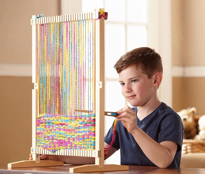 A model demonstrating how to use the wooden loom on a table
