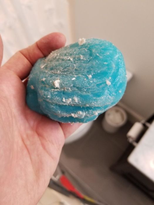 A reviewer showing dirty cleaning putty after using it, highlighting its effectiveness in picking up dirt and debris.