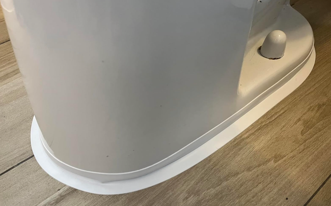 A close-up view of a contemporary, stylish white electric kettle placed on a wooden countertop