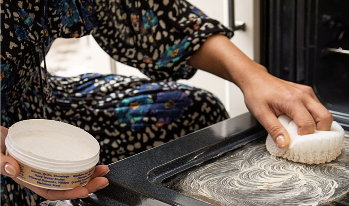 A model applying the cleaning paste to an oven door