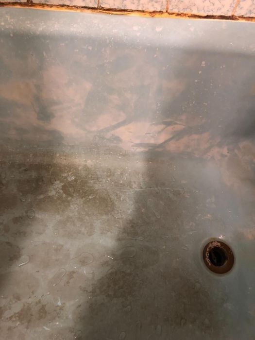 A reviewer’s tub covered in soap scum, before using the soap scum remover spray.