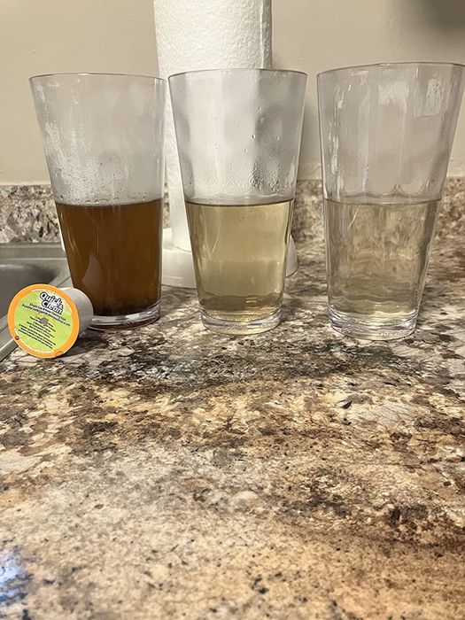 A reviewer shares an image of three cups filled with water in varying shades, showing how the Keurig gets cleaned.