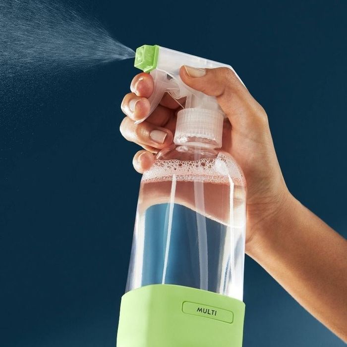 A person sprays the cleaning solution from the spray bottle