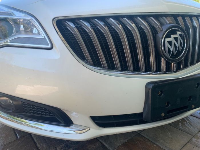 A reviewer’s photo of a white car with a pristine bumper, completely free of bug splatters