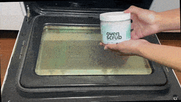 A gif showing a person using the scrub to clean their oven