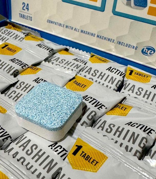 A box containing 24 individually wrapped laundry detergent tablets, each white with blue specks, labeled