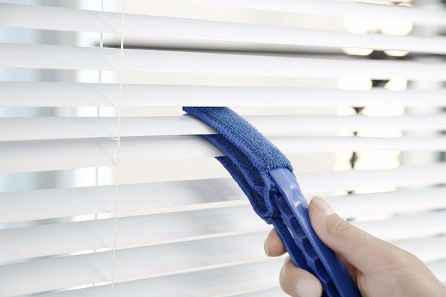 The wand simultaneously cleaning three surfaces of Venetian blinds.