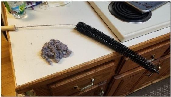 A reviewer’s photo showcasing the dust collected by the flexible coil brush, revealing how effective it is at reaching deep spaces.