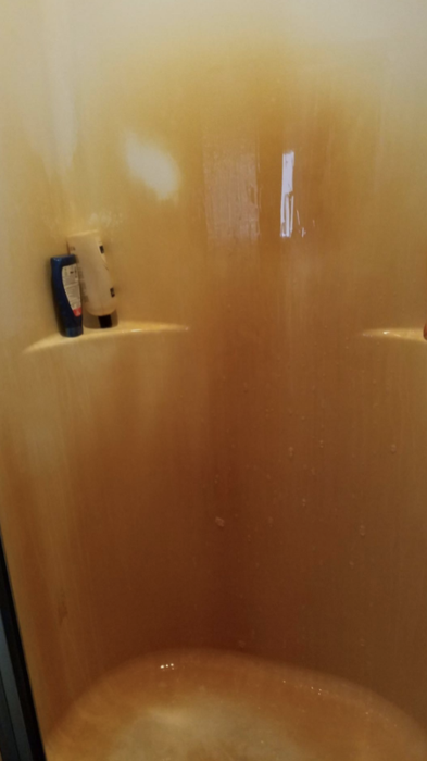 Reviewer photo of a shower surround covered in rust stains