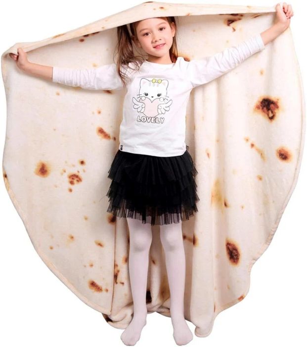 A child holding up the tortilla blanket