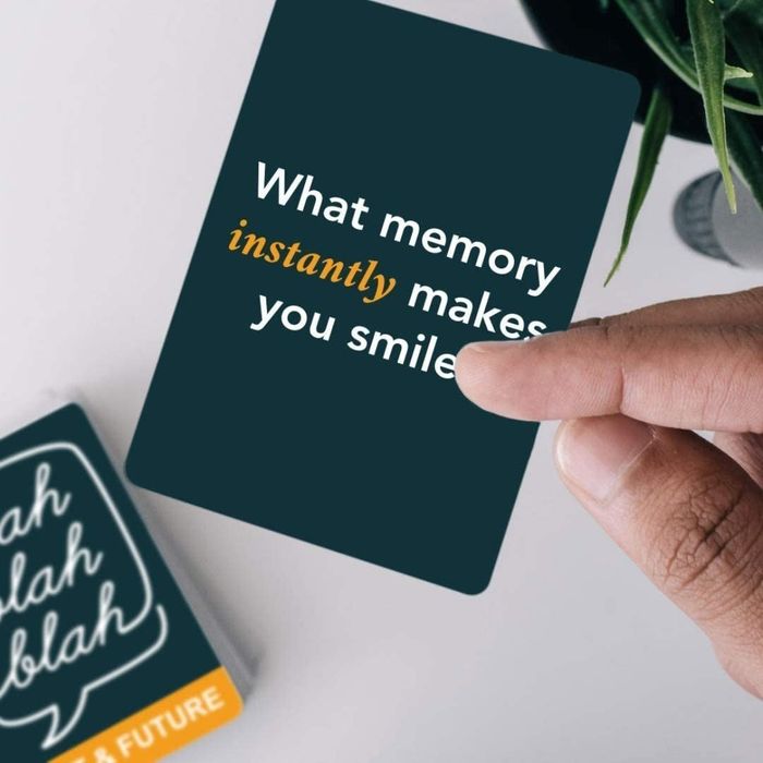 A hand holding a card that reads: what memory instantly makes you smile