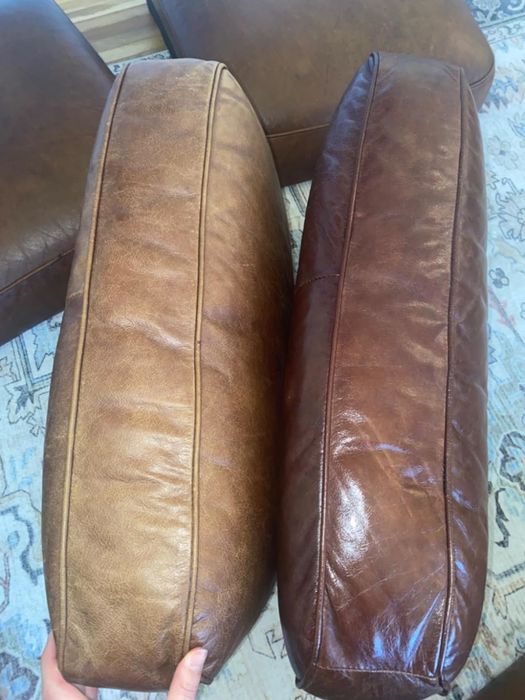 Two hands holding and comparing two leather cushions; one is light brown, and the other is dark brown