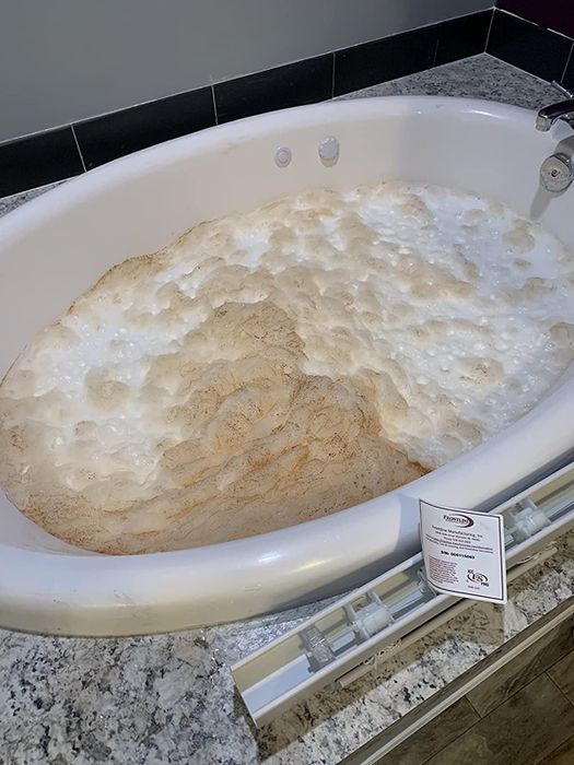 A reviewer captures an image of a jetted tub releasing dirty foam.