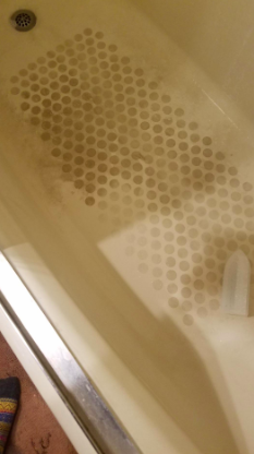 A bathtub floor covered in grime