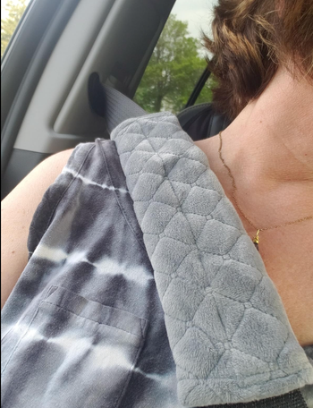 A gray version of the seatbelt pad shown on a different seatbelt.