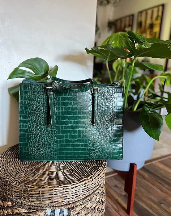 A handbag with green faux snakeskin handles