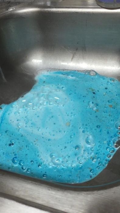 A sink filled with blue foam.