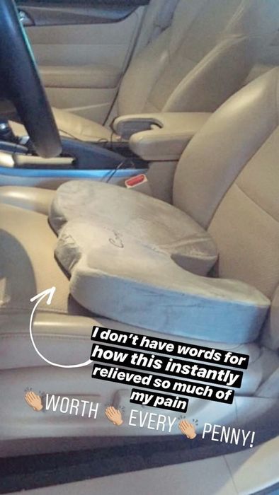 a gray pillow on a car seat with the text