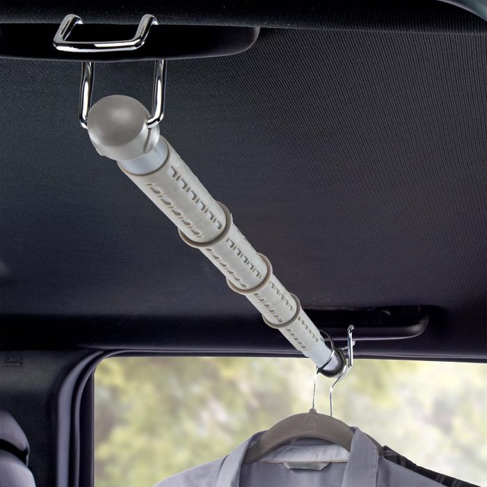 A clothes hanger bar attached to the interior handles of a car.