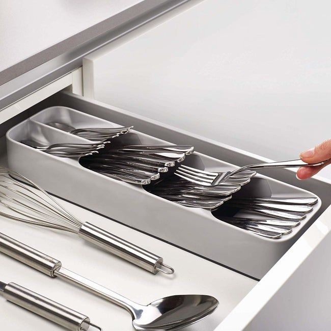 A grey organizer with silverware neatly arranged at an angle inside.