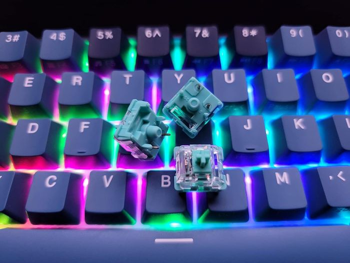 An RGB-backlit keyboard with teal mechanical switches on top, displaying the customizable features perfect for both gaming and typing enthusiasts