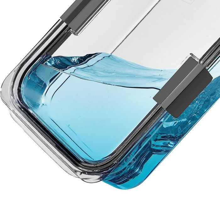 A container tipped on its side, filled with blue liquid, demonstrating how it remains completely leakproof.
