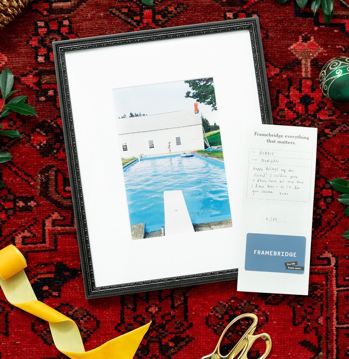 A framed photo placed beside a gift card that features a heartfelt personalized note.