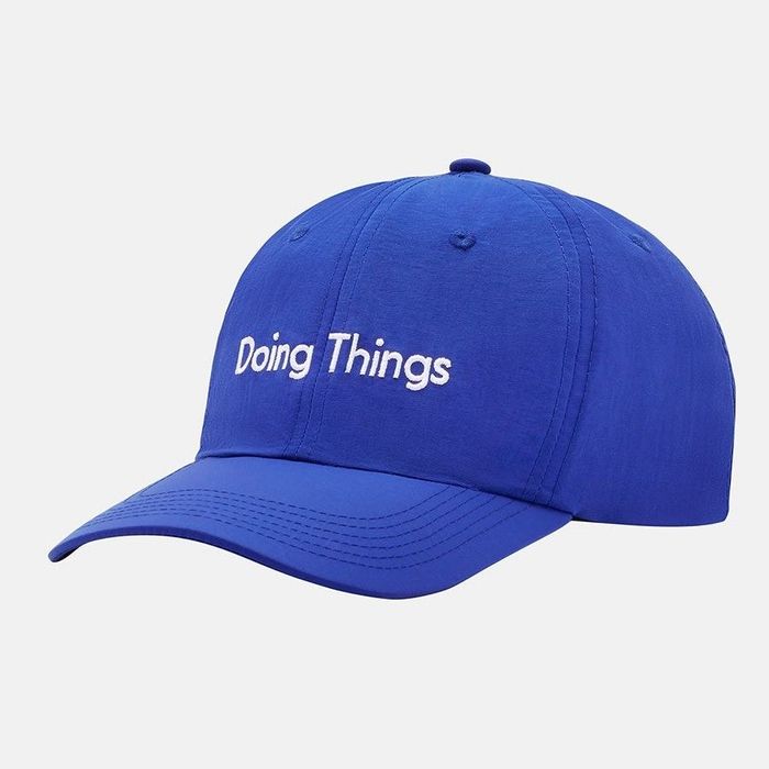 A front view of the blue hat featuring a simple, stylish design that says