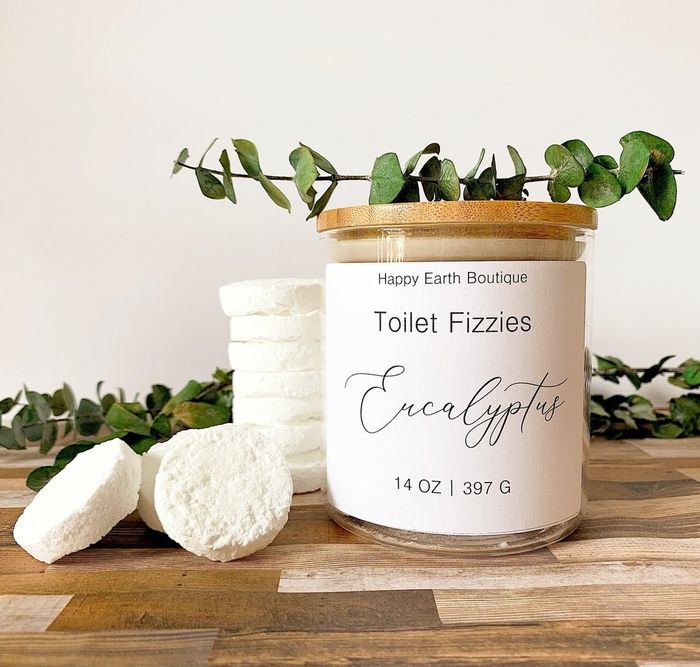A jar filled with white fizzy toilet bombs, shaped like coins.