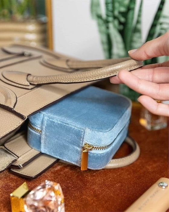 The blue jewelry case tucked inside a purse.
