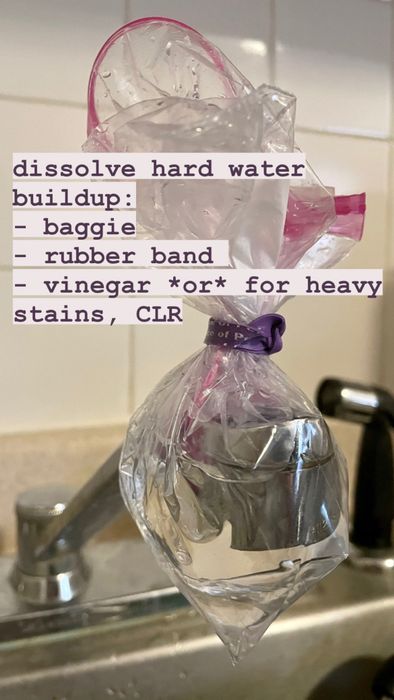 A kitchen faucet with a plastic bag filled with vinegar, tightly secured over the nozzle with a rubber band.