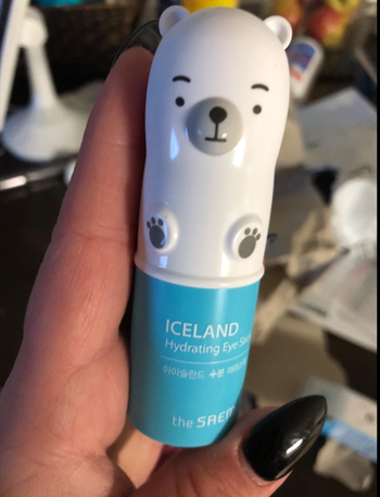 The small, polar bear-shaped eye stick being held in a reviewer's hands.