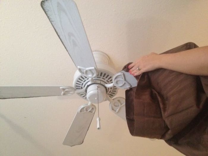 Hands placing a fan blade inside of a pillowcase.