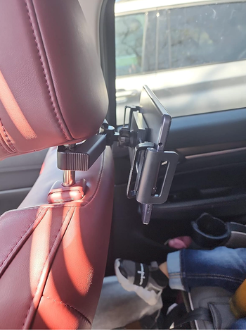 A side view of the iPad holder attached to a seat, showing its adjustable arms