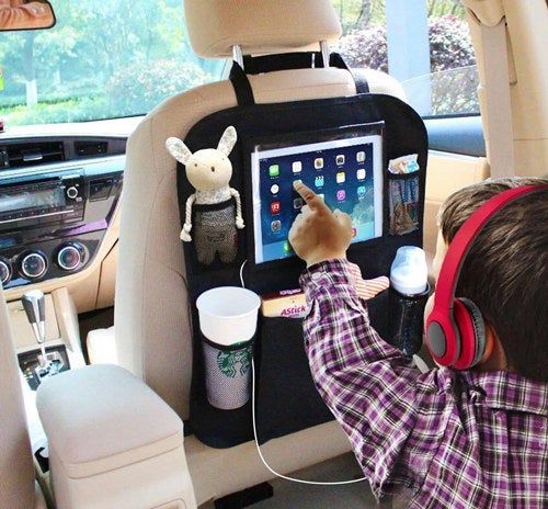 The organizer holding an iPad, stuffed animal, coffee cup, and other items while the child uses the iPad