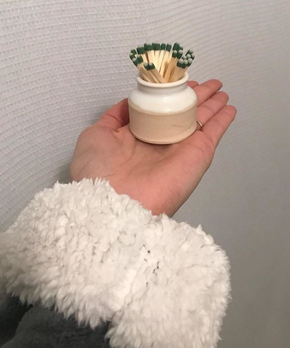 A reviewer holding the match striker delicately in their hand.