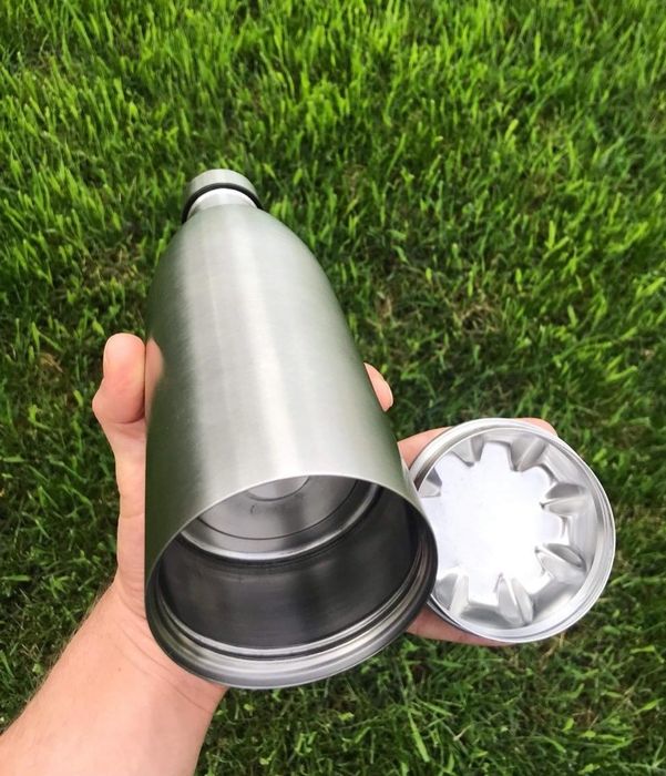 A reviewer holding the bottle with its bottom removed.