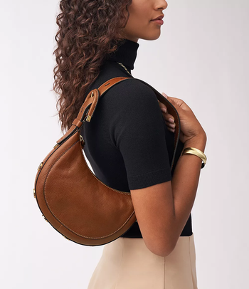 A model showcasing the brown shoulder bag.