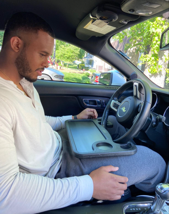 A person sitting at the wheel with the tray attached