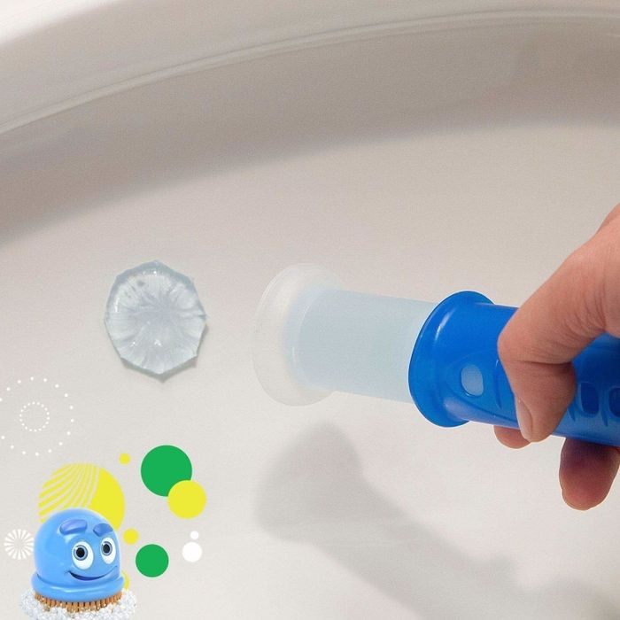 A hand using a tool to press a circle of gel into the inside of a toilet bowl.